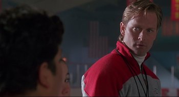 Movie still from “D3: The Mighty Ducks” (1996), directed by Robert Lieberman – A man in a red and gray jacket looking at a woman in a red and gray jacket; Close Up shot, Over the shoulder angle