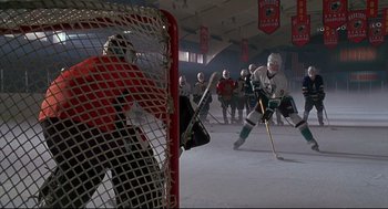 Movie still from “D3: The Mighty Ducks” (1996), directed by Robert Lieberman – A group of men playing a game of ice hockey; Wide shot, High angle