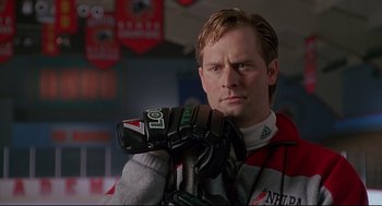 Movie still from “D3: The Mighty Ducks” (1996), directed by Robert Lieberman – A man in a hockey sweater holding a hockey glove; Close Up shot, Low angle