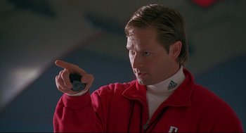 Movie still from “D3: The Mighty Ducks” (1996), directed by Robert Lieberman – A man in a red jacket holding a remote control; Close Up shot, Low angle