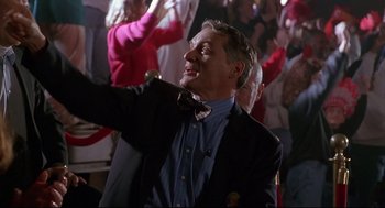 Movie still from “D3: The Mighty Ducks” (1996), directed by Robert Lieberman – A man wearing a suit and a bow tie; Medium shot, Low angle