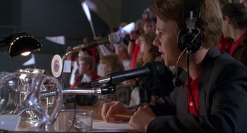 Movie still from “D3: The Mighty Ducks” (1996), directed by Robert Lieberman – A boy is sitting in front of a microphone; Medium shot, Low angle