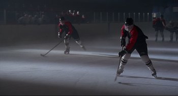 Movie still from “D3: The Mighty Ducks” (1996), directed by Robert Lieberman – A couple of men playing a game of ice hockey; Wide shot, High angle