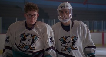 Movie still from “D3: The Mighty Ducks” (1996), directed by Robert Lieberman – A couple of people that are wearing hockey uniforms; Medium shot, Low angle