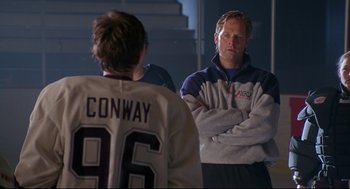 Movie still from “D3: The Mighty Ducks” (1996), directed by Robert Lieberman – A man standing next to another man in front of a mirror; Medium shot, Over the shoulder angle