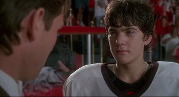 Movie still from “D3: The Mighty Ducks” (1996), directed by Robert Lieberman – A young man is looking at the camera while another man looks at him; Close Up shot, Low angle