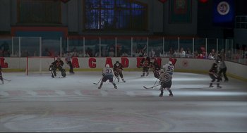 Movie still from “D3: The Mighty Ducks” (1996), directed by Robert Lieberman – A group of men playing a game of ice hockey; Extreme Wide shot, High angle