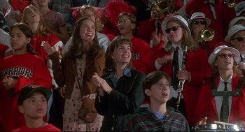 Movie still from “D3: The Mighty Ducks” (1996), directed by Robert Lieberman – A group of people standing in front of a microphone; Medium shot, High angle