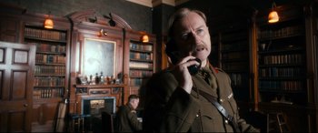Movie still from “Dad's Army” (2016), directed by Oliver Parker – A man in a military uniform talking on a cell phone; Medium shot, Low angle