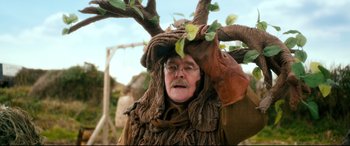 Movie still from “Dad's Army” (2016), directed by Oliver Parker – An old man dressed as a tree for a costume party; Medium shot, Over the shoulder angle