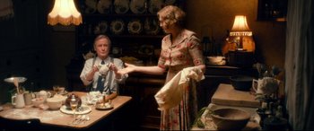 Movie still from “Dad's Army” (2016), directed by Oliver Parker – A man and a woman are sitting at a table; Medium shot, High angle