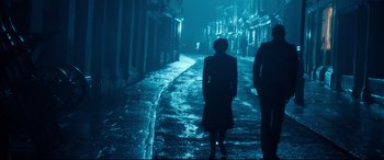 Movie still from “Dad's Army” (2016), directed by Oliver Parker – Two people are standing on a street at night; Wide shot, Low angle