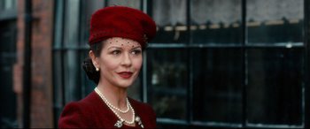 Movie still from “Dad's Army” (2016), directed by Oliver Parker – A woman wearing a red hat and a red jacket; Close Up shot, Over the shoulder angle