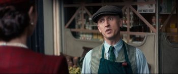 Movie still from “Dad's Army” (2016), directed by Oliver Parker – A man wearing an apron and a hat standing in a store; Medium shot, Over the shoulder angle