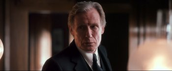 Movie still from “Dad's Army” (2016), directed by Oliver Parker – An older man wearing a suit and tie; Close Up shot, Over the shoulder angle