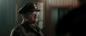 Movie still from “Dad's Army” (2016), directed by Oliver Parker – An older man wearing a hat and glasses; Close Up shot, Over the shoulder angle