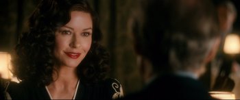 Movie still from “Dad's Army” (2016), directed by Oliver Parker – A beautiful woman with red lipstick smiling for the camera; Close Up shot, Over the shoulder angle