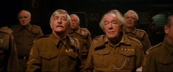 Movie still from “Dad's Army” (2016), directed by Oliver Parker – A group of men in uniform standing next to each other; Medium shot, Low angle