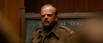 Movie still from “Dad's Army” (2016), directed by Oliver Parker – A man in a military uniform standing in front of a chalkboard; Close Up shot, Low angle