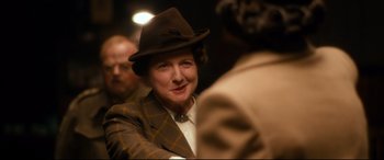 Movie still from “Dad's Army” (2016), directed by Oliver Parker – An older woman wearing a hat and a suit; Close Up shot, Over the shoulder angle
