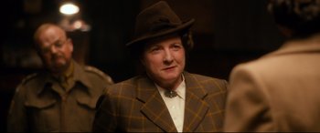 Movie still from “Dad's Army” (2016), directed by Oliver Parker – An older woman wearing a hat and a suit; Close Up shot, Low angle