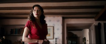 Movie still from “Dad's Army” (2016), directed by Oliver Parker – A woman in a red dress standing in front of a wall; Medium shot, Low angle