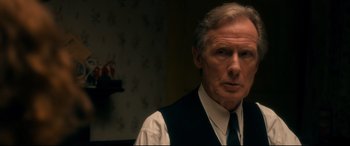 Movie still from “Dad's Army” (2016), directed by Oliver Parker – An older man wearing a vest and a tie; Close Up shot, Over the shoulder angle