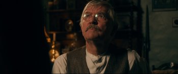 Movie still from “Dad's Army” (2016), directed by Oliver Parker – An older man wearing glasses and a vest; Close Up shot, Over the shoulder angle