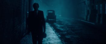 Movie still from “Dad's Army” (2016), directed by Oliver Parker – A man walking down a street in the dark; Wide shot, Over the shoulder angle