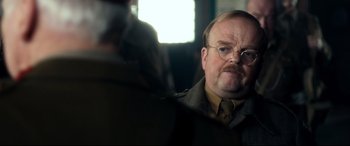 Movie still from “Dad's Army” (2016), directed by Oliver Parker – A man with a mustache and glasses looking into a mirror; Close Up shot, Over the shoulder angle