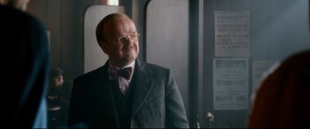 Movie still from “Dad's Army” (2016), directed by Oliver Parker – An older man wearing a suit and bow tie; Close Up shot, Over the shoulder angle