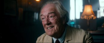 Movie still from “Dad's Army” (2016), directed by Oliver Parker – An older man wearing a suit and tie; Close Up shot, Over the shoulder angle
