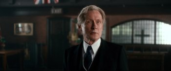 Movie still from “Dad's Army” (2016), directed by Oliver Parker – An older man wearing a suit and tie; Medium shot, Low angle