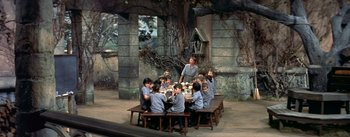 Movie still from “Daddy Long Legs” (1955), directed by Jean Negulesco – A group of children sitting around a table; Wide shot, High angle