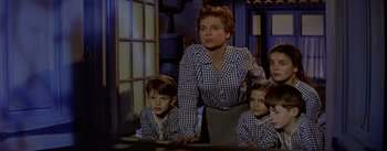 Movie still from “Daddy Long Legs” (1955), directed by Jean Negulesco – A woman and two children in a room; Medium shot, Low angle