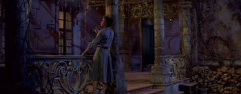 Movie still from “Daddy Long Legs” (1955), directed by Jean Negulesco – A woman standing in front of a balcony; Wide shot, Low angle