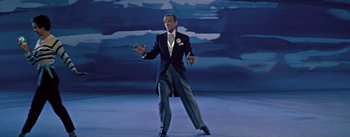 Movie still from “Daddy Long Legs” (1955), directed by Jean Negulesco – A man in a suit and tie standing in front of a painting; Medium shot, High angle