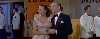 Movie still from “Daddy Long Legs” (1955), directed by Jean Negulesco – An older man and a young woman in a dress and tuxedo; Medium shot, Low angle