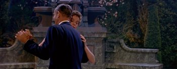 Movie still from “Daddy Long Legs” (1955), directed by Jean Negulesco – A man and a woman dancing in front of a stone wall; Medium shot, Low angle