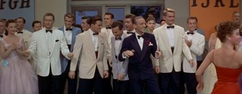 Movie still from “Daddy Long Legs” (1955), directed by Jean Negulesco – A group of men standing next to each other in tuxedos; Medium shot, High angle