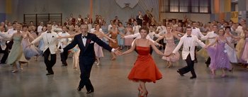 Movie still from “Daddy Long Legs” (1955), directed by Jean Negulesco – A group of people dancing in front of a large crowd; Wide shot, High angle