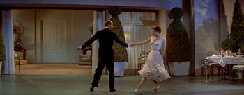 Movie still from “Daddy Long Legs” (1955), directed by Jean Negulesco – A man and a woman are dancing in front of a tree; Wide shot, Low angle