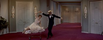 Movie still from “Daddy Long Legs” (1955), directed by Jean Negulesco – A man and a woman dancing in front of a mirror; Wide shot, High angle