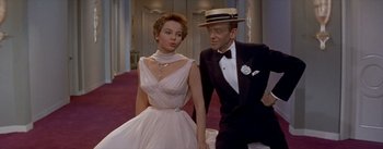 Movie still from “Daddy Long Legs” (1955), directed by Jean Negulesco – A man and a woman holding hands while standing next to each other; Medium shot, Low angle