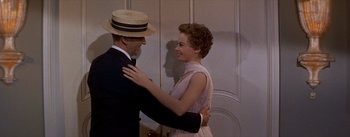 Movie still from “Daddy Long Legs” (1955), directed by Jean Negulesco – A man and a woman dancing in a room together; Medium shot, Over the shoulder angle