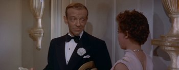 Movie still from “Daddy Long Legs” (1955), directed by Jean Negulesco – A man in a tuxedo and a woman in a white dress; Close Up shot, Over the shoulder angle