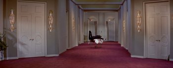 Movie still from “Daddy Long Legs” (1955), directed by Jean Negulesco – A person sitting on a chair in a room with red carpeting; Extreme Wide shot, High angle