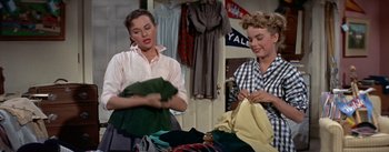 Movie still from “Daddy Long Legs” (1955), directed by Jean Negulesco – Two women are doing laundry in a room; Medium shot, Low angle