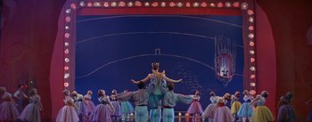 Movie still from “Daddy Long Legs” (1955), directed by Jean Negulesco – A group of people standing on top of each other on a stage; Wide shot, Low angle