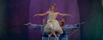 Movie still from “Daddy Long Legs” (1955), directed by Jean Negulesco – A group of men and a woman performing a dance; Medium shot, Low angle